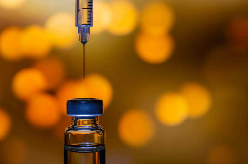 close up of needle and vaccine bottle
