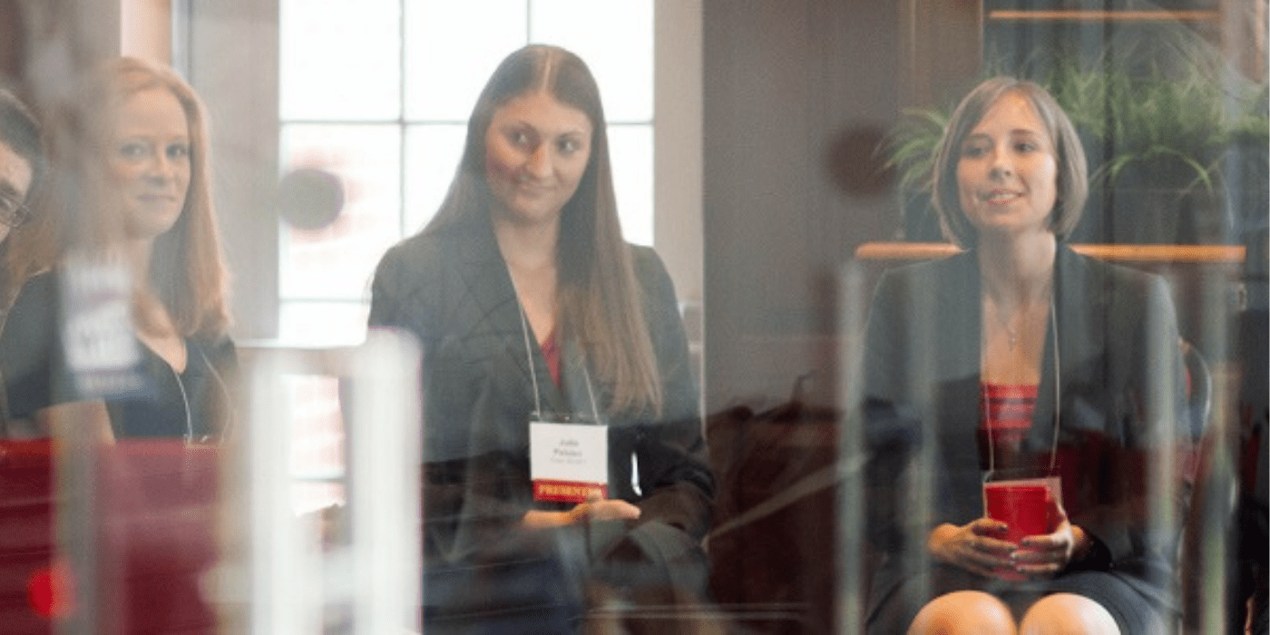 three female panelists sit in conference room