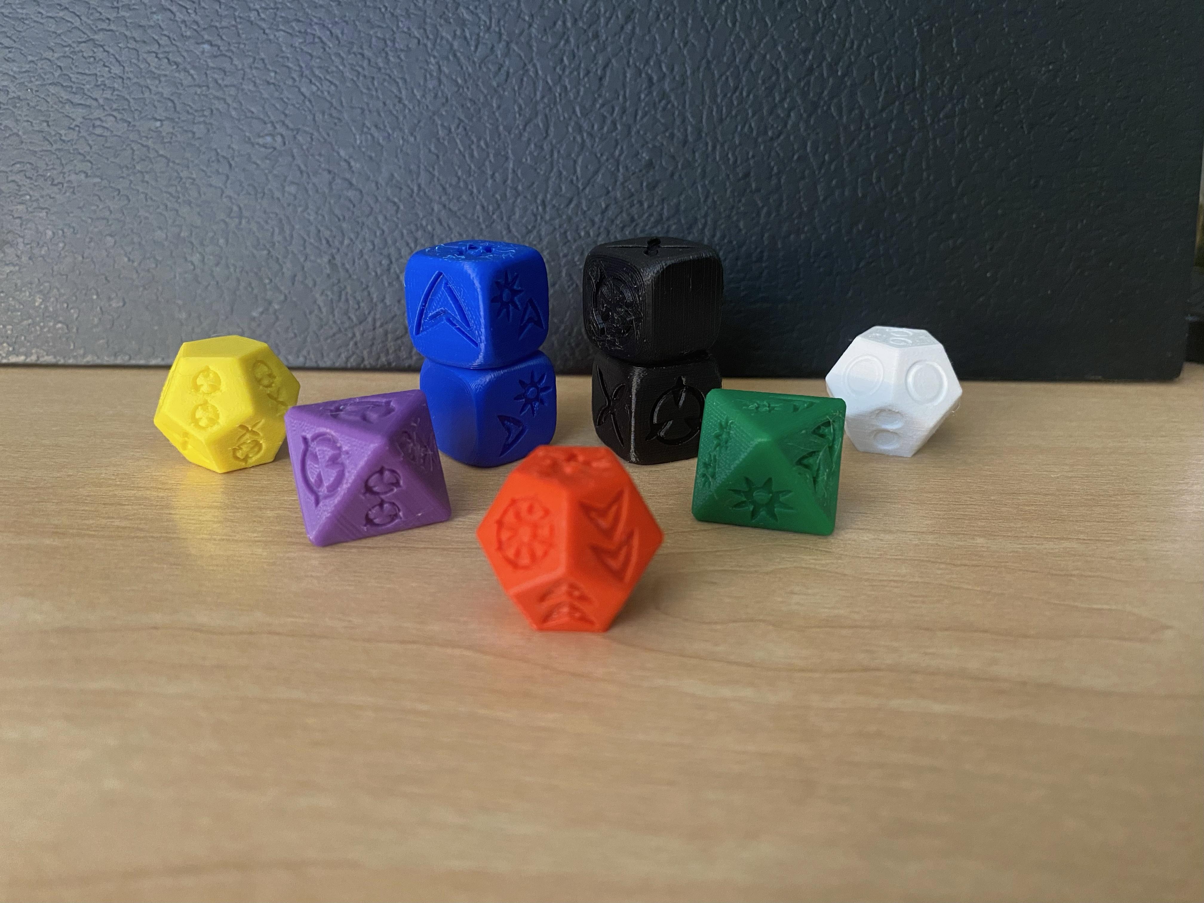 Nine 3D-printed narrative dice of various colors on a table