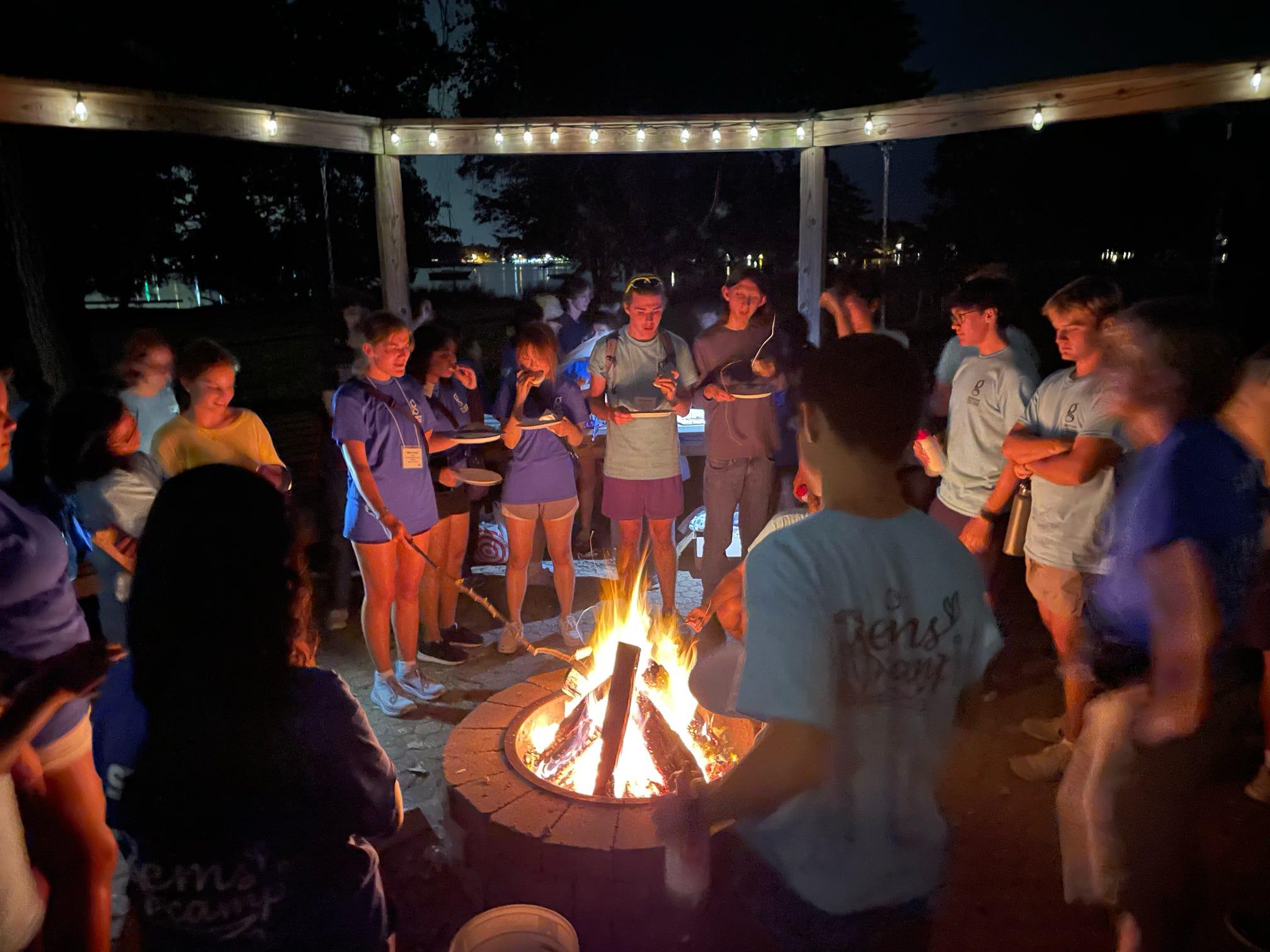 Group of students standing in front of a campfire