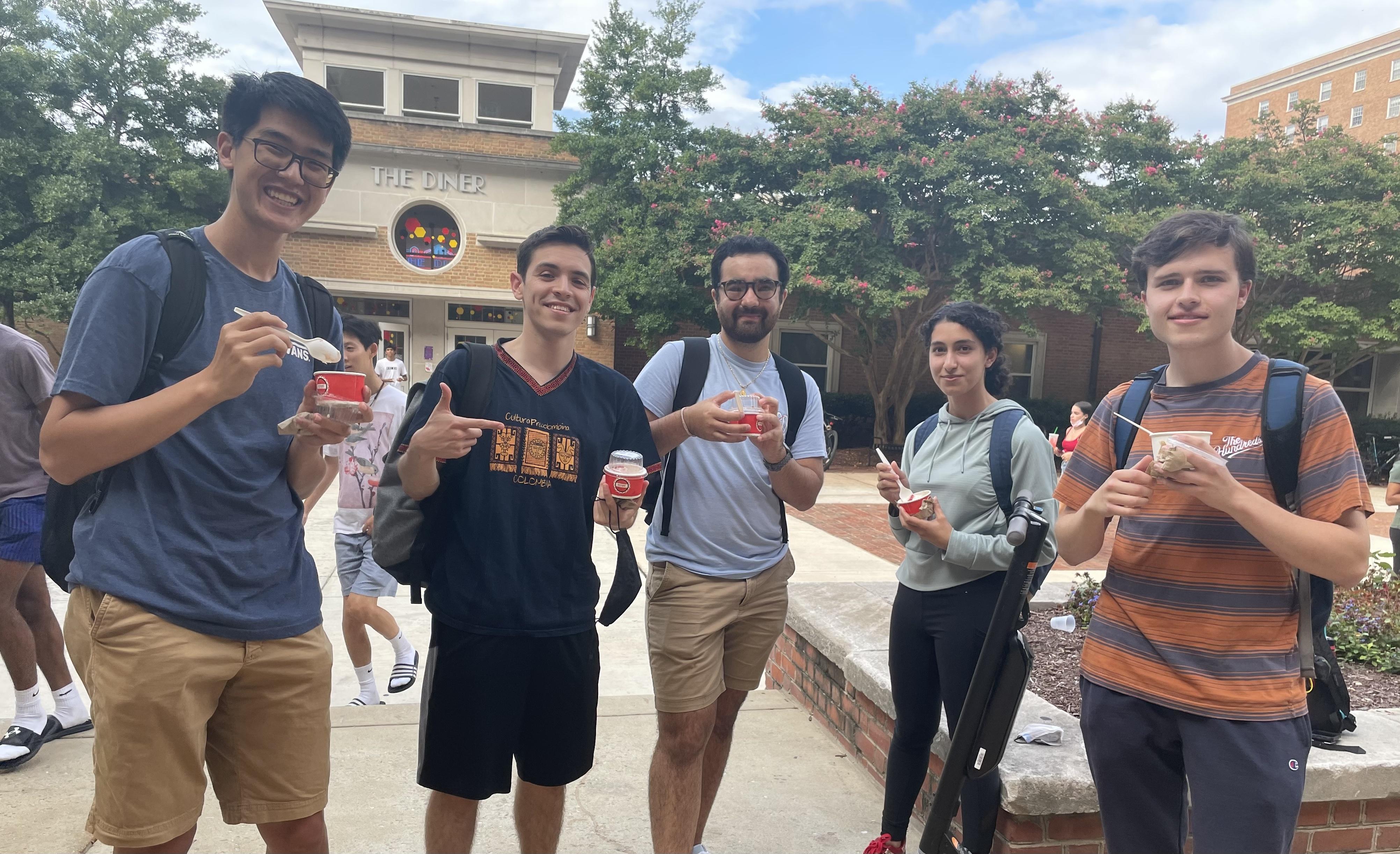 Five students hold cups of ice cream and smiling for photo