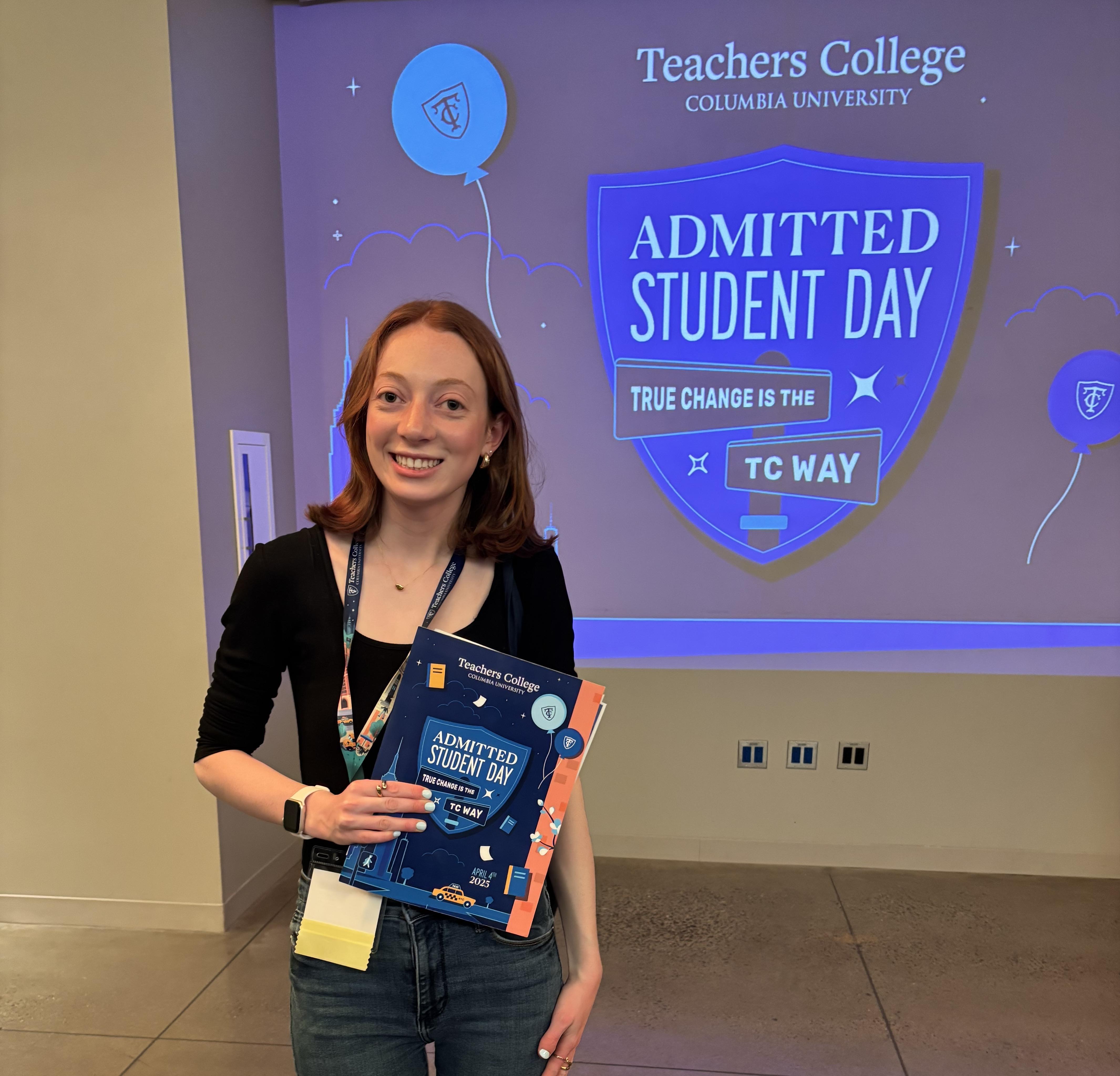 Stephanie Fishkin standing in front of a screen that says "Admitted student day" at Teachers College Columbia
