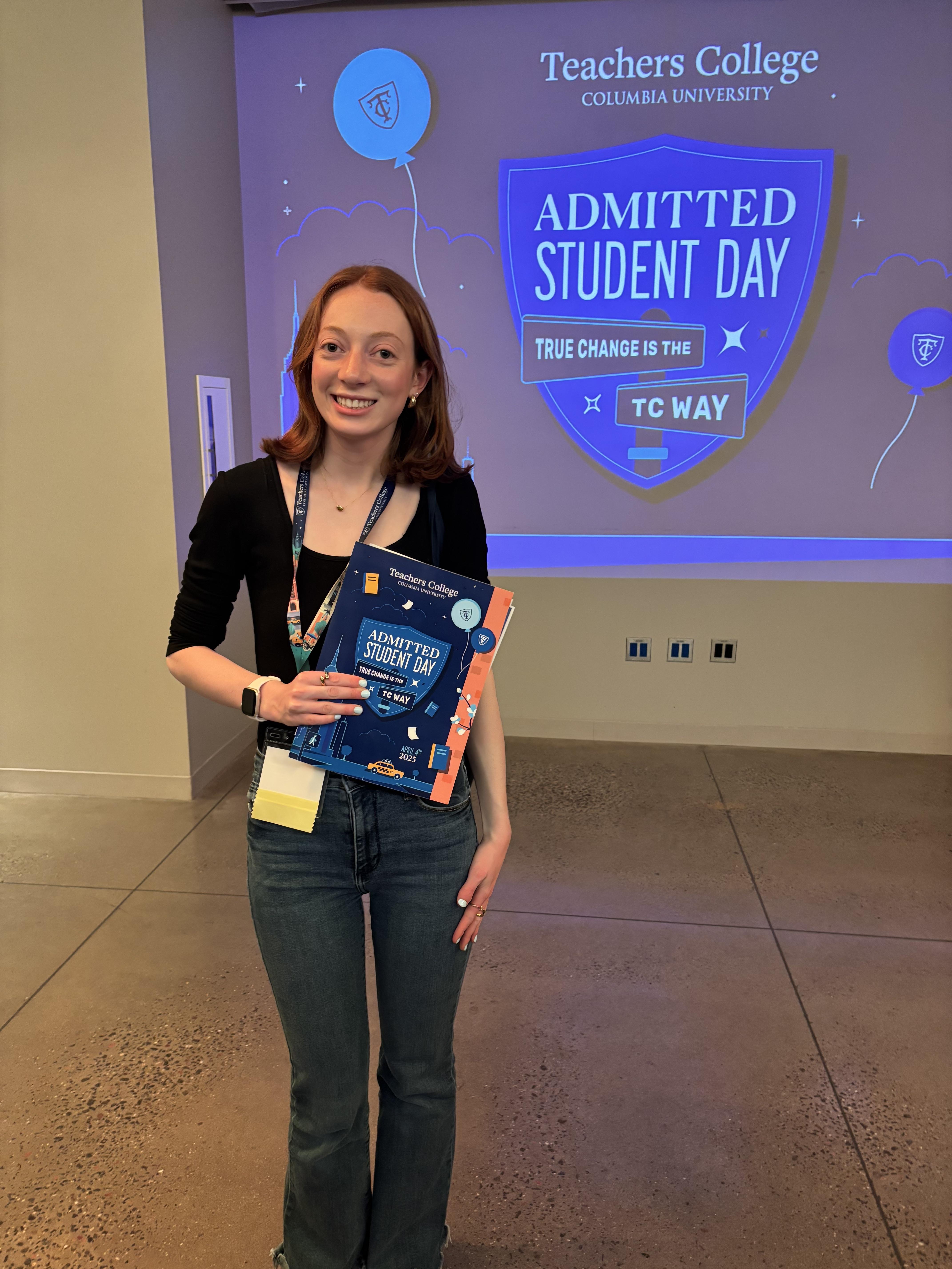 Stephanie Fishkin standing in front of a screen that says "Admitted student day" at Teachers College Columbia