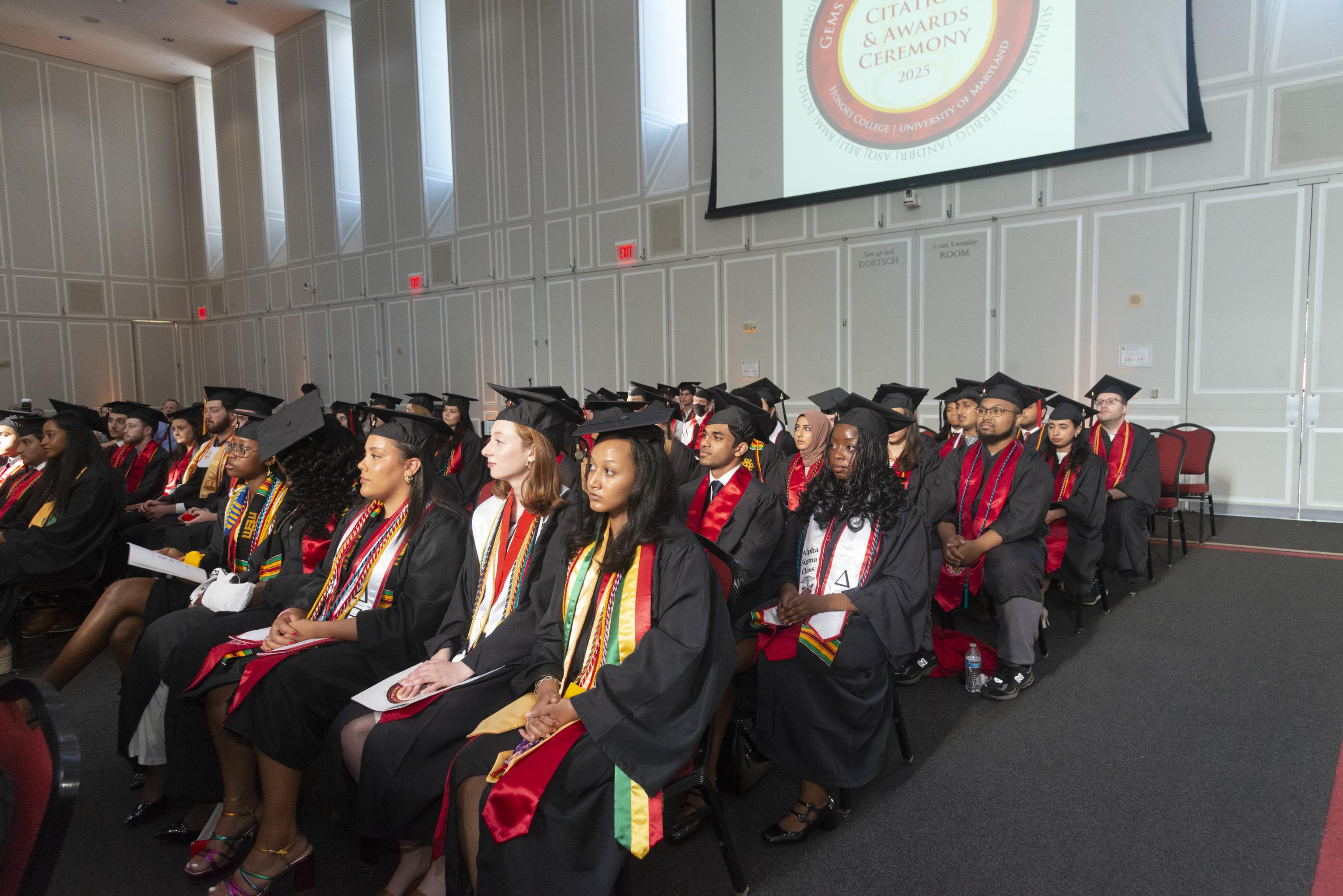 Gemstone students in graduation caps and gowns seated in rows