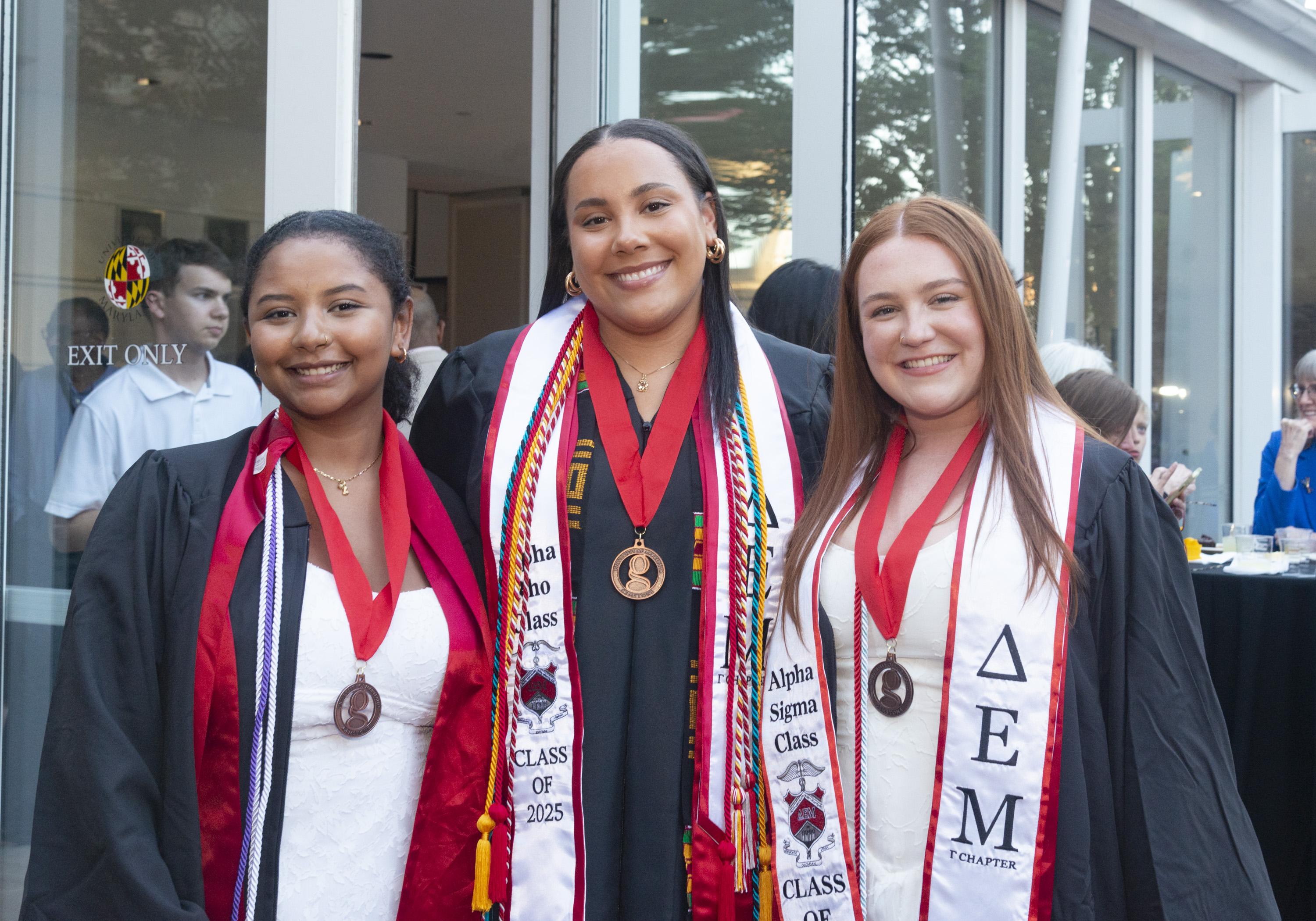 Three Gemstone students wearing graduation gowns