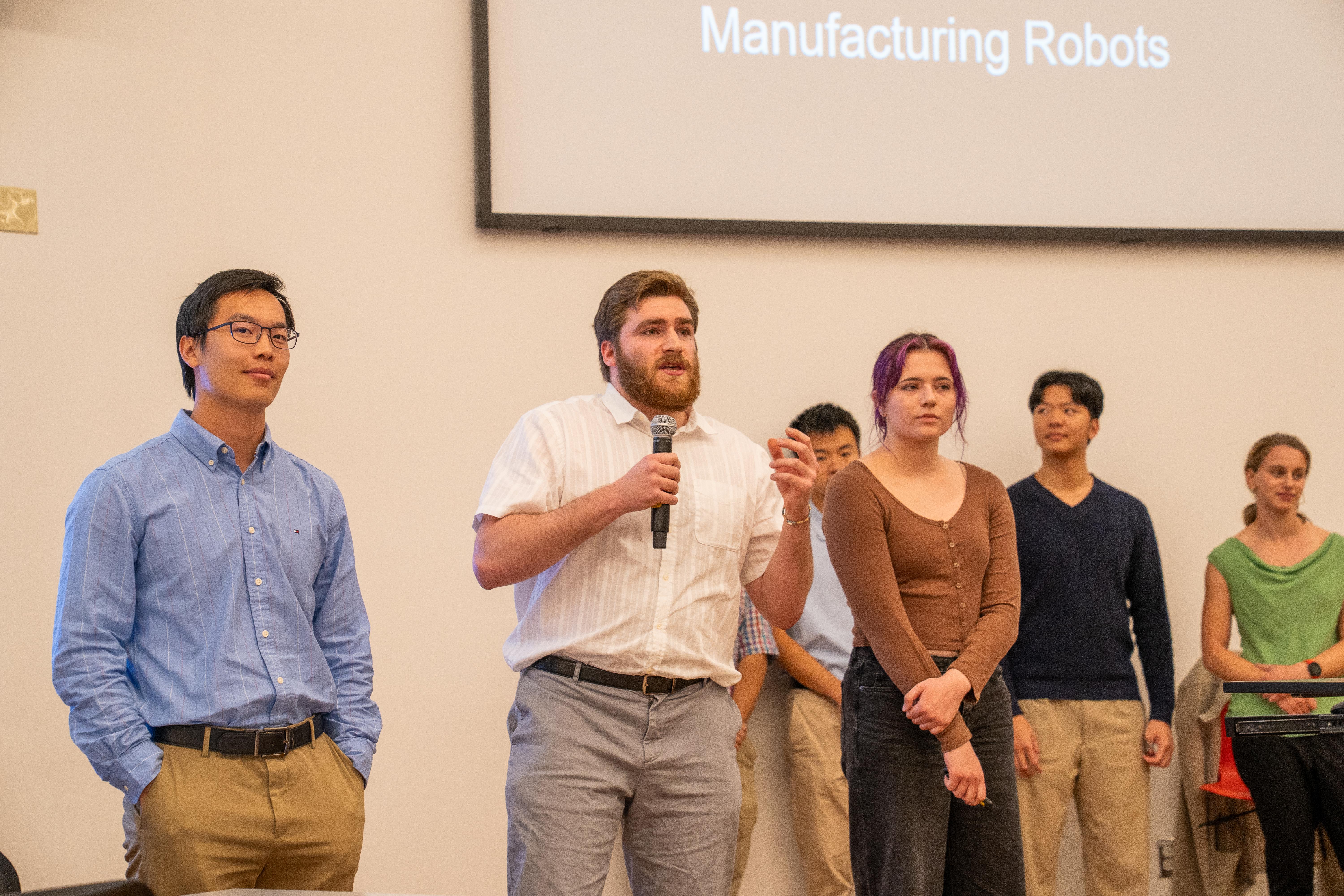 Gemstone student holding microphone with teammates in the background